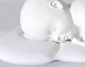 顔埋め防止のくぼみと寝ている赤ちゃんの説明。公式HPより。
